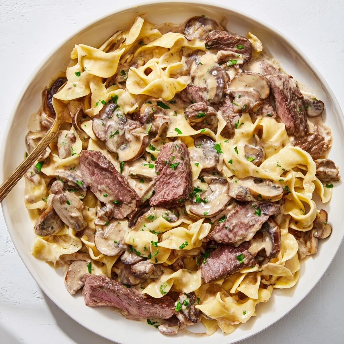 Creamy One-Pan Beef Stroganoff Skillet topped with fresh parsley and mushrooms.  
