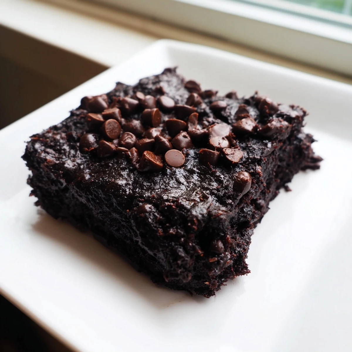 A plate of moist Black Bean Brownies, showcasing a rich, dark color and perfect for dessert.