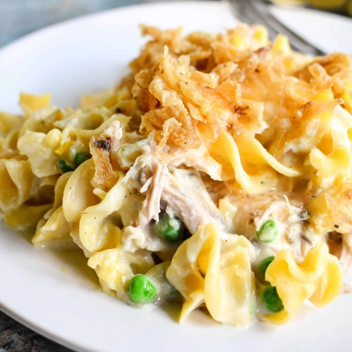Golden, bubbly Homemade Tuna Noodle Casserole with a crispy onion topping, ready to serve with family.