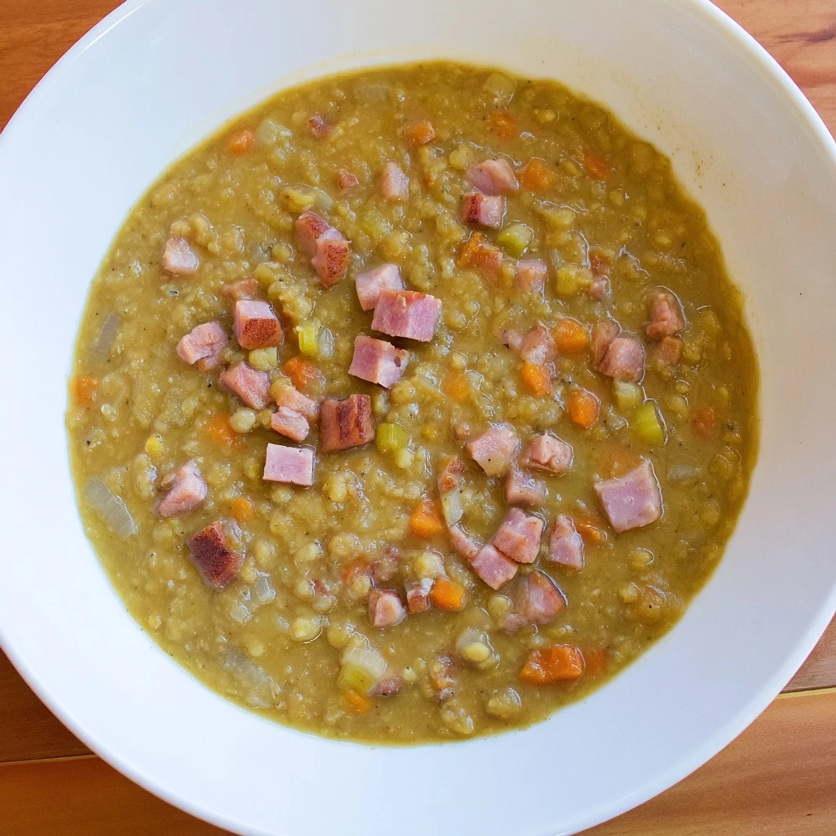 Steaming bowl of Hearty Split Pea and Ham Soup; a rich, thick soup with ham and vegetables.