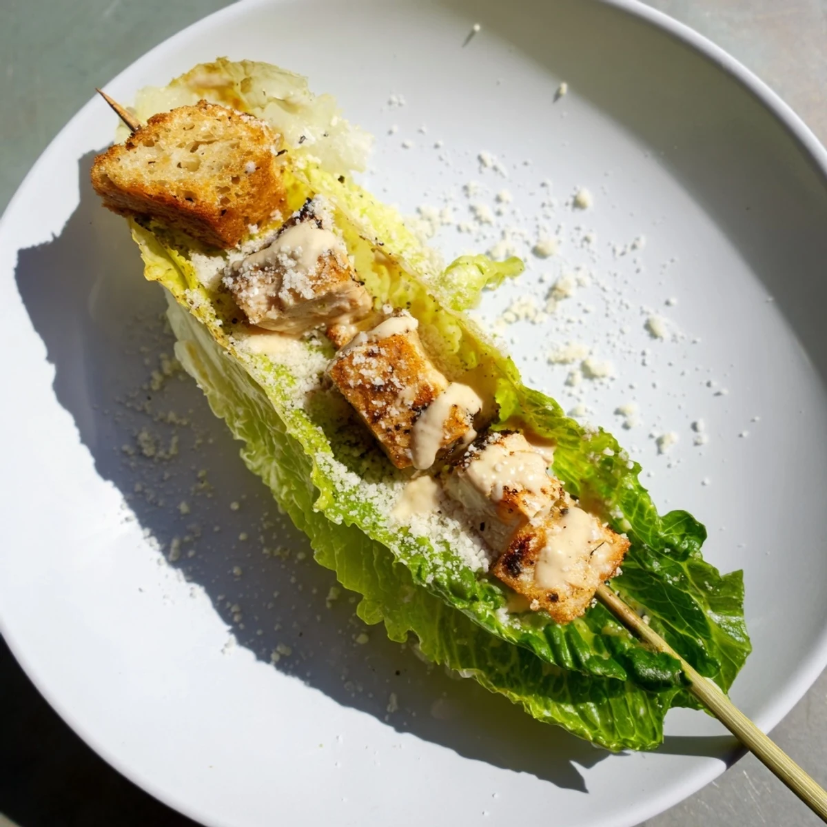 Close-up of Chicken Caesar Salad Skewers: tender chicken and crisp romaine lettuce, drizzled with Caesar dressing.