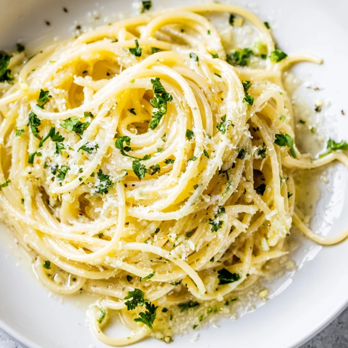 Steam rises from a forkful of Lemon Butter Pasta Light, revealing tender angel hair pasta tossed in a buttery lemon sauce with herbs and freshly ground pepper.