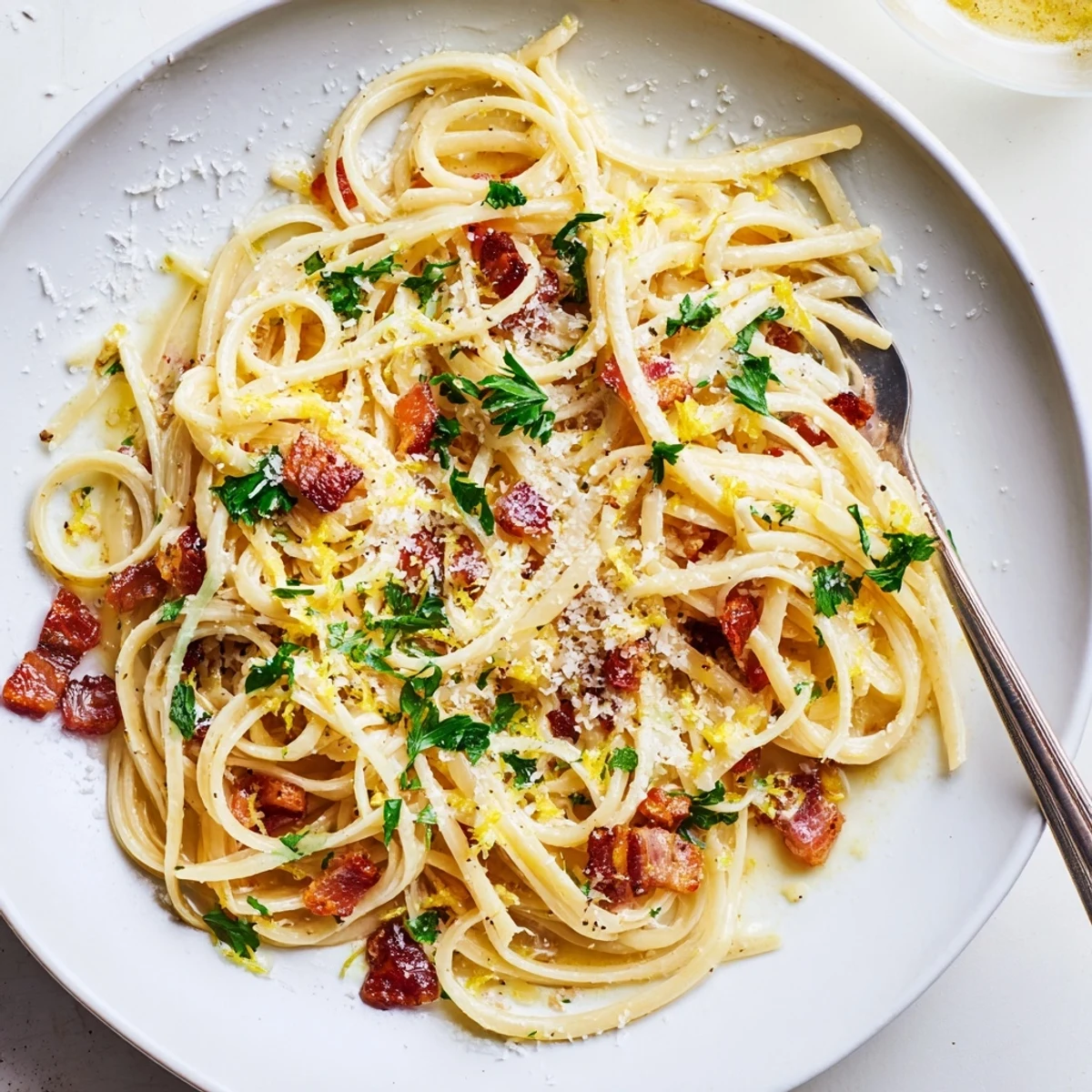 Crispy Bacon Linguine served hot with a sprinkle of Parmesan on a rustic wooden table.