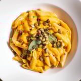 A close-up view of creamy Vegan Creamy Pumpkin Pasta, showcasing the rich pumpkin sauce's texture.