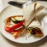 The Snowflake Hummus & Roasted Veggie Wrap offers a satisfying lunch, featuring vibrant vegetables and flavorful hummus.