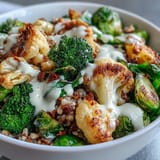 Golden roasted broccoli, cauliflower, and Brussels sprouts rest on a bed of fluffy quinoa in this vibrant Roasted Brassica Bowl.  