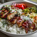 Assembled BBQ Chicken Bowl featuring juicy BBQ chicken, creamy coleslaw, and golden roasted vegetables on a bed of fluffy rice.