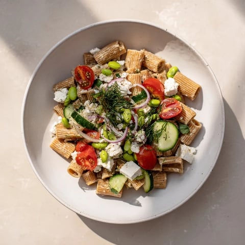 Holiday Glow Green Goddess Protein Pasta Salad, a creamy, vibrant dish with fresh herbs and colorful veggies.