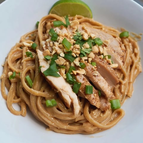 Steaming Thai Peanut Chicken Pasta, offering a vibrant mix with fresh cilantro and crunchy peanuts.