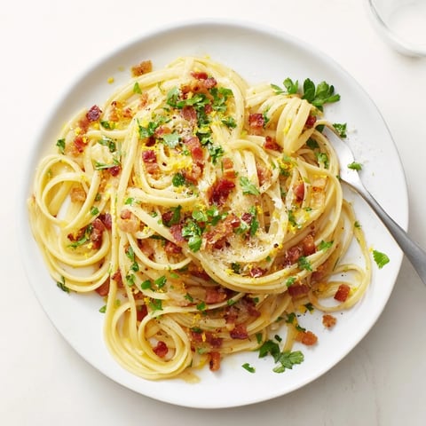 Steaming bowls of Crispy Bacon Linguine glisten with silky garlic sauce and fresh parsley garnish.