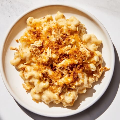 A close-up of a casserole presents this delicious Classic Mac & Cheese with BBQ Chicken ready to serve.