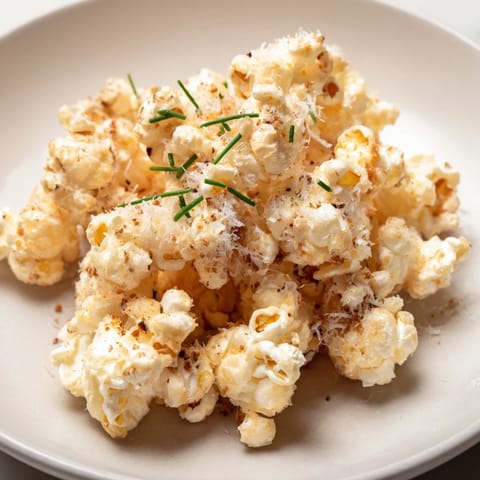 A vibrant close-up shows diverse savoury popcorn mixes with herbs and flavorful seasonings perfect for sharing.
