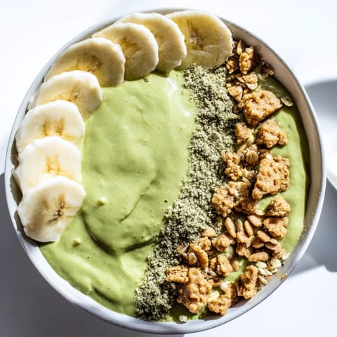 Creamy green matcha gingerbread cookie smoothie bowl, scattered with festive cookie crumbles.