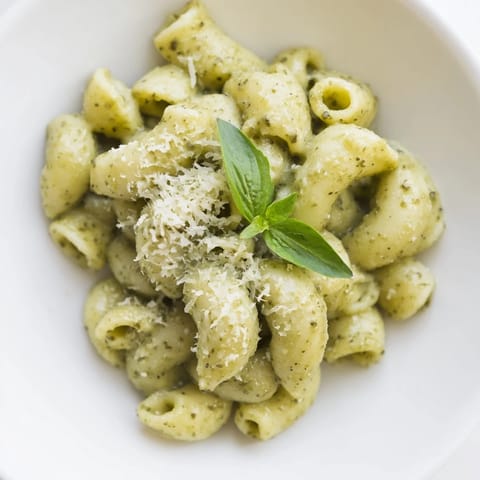 Creamy avocado pesto mac tossed with al dente pasta, bright green sauce glistening with olive oil.  