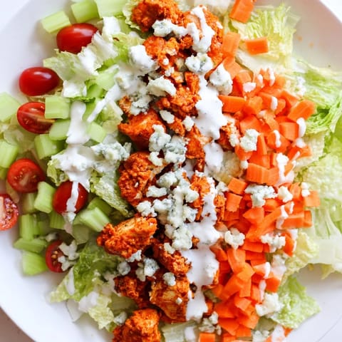 A vibrant Buffalo Chicken Chopped Salad with spicy chicken, crisp romaine, celery, and blue cheese crumbles, ready to serve.