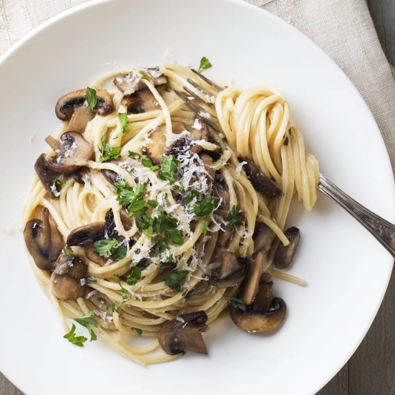 A steaming bowl of Creamy Mushroom Linguine topped with fresh parsley and shaved Parmesan, perfect for an elegant vegetarian dinner.